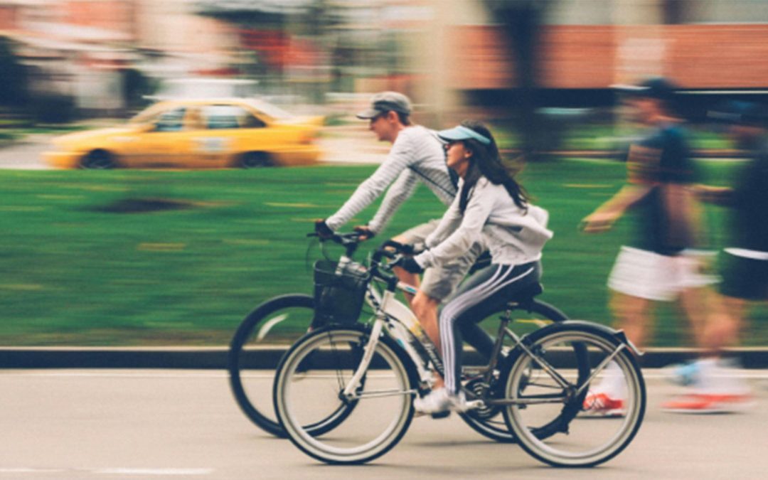 Ett par som cyklar i en stad